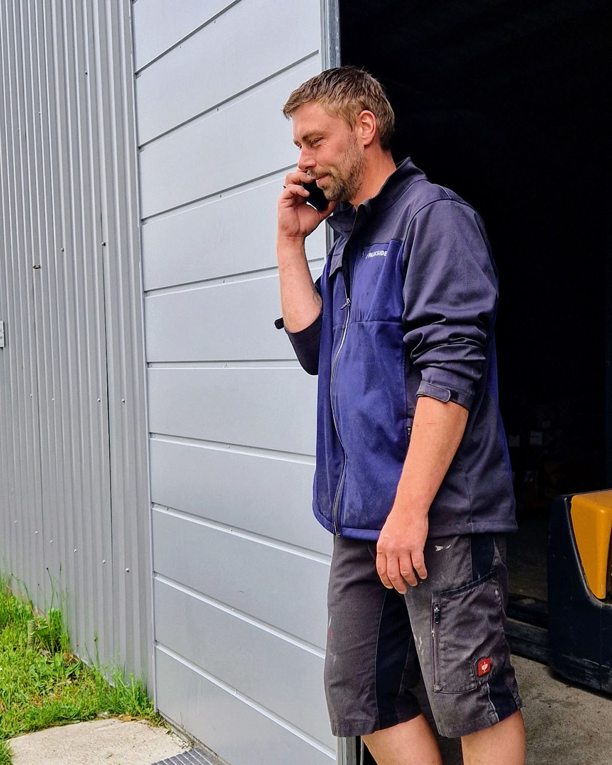 Mitarbeiter beim Telefonieren im Lagerbereich